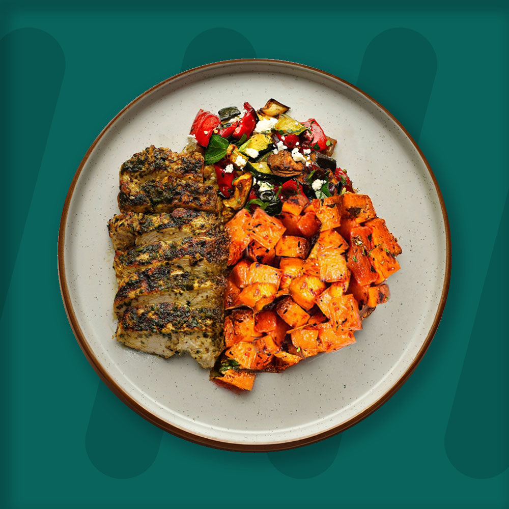  A colorful plate featuring shredded Mexican-spiced chicken garnished with fresh herbs, served alongside a portion of vibrant green cilantro rice. Complementing the dish is a side of roasted corn mixed with crumbled feta cheese, adding a touch of creaminess and texture. The meal is presented on a minimalist ceramic plate with a dark rim, set against a rich green background for a fresh and appetizing presentation. prepped meal.