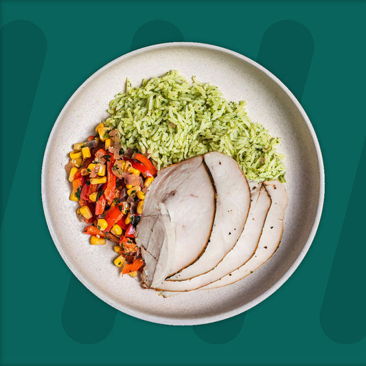  A colorful plate featuring shredded Mexican-spiced chicken garnished with fresh herbs, served alongside a portion of vibrant green cilantro rice. Complementing the dish is a side of roasted corn mixed with crumbled feta cheese, adding a touch of creaminess and texture. The meal is presented on a minimalist ceramic plate with a dark rim, set against a rich green background for a fresh and appetizing presentation. prepped meal.