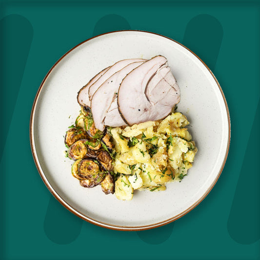  A colorful plate featuring shredded Mexican-spiced chicken garnished with fresh herbs, served alongside a portion of vibrant green cilantro rice. Complementing the dish is a side of roasted corn mixed with crumbled feta cheese, adding a touch of creaminess and texture. The meal is presented on a minimalist ceramic plate with a dark rim, set against a rich green background for a fresh and appetizing presentation. prepped meal.